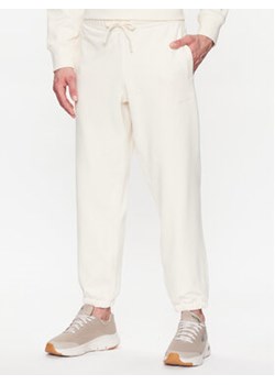 New Balance Spodnie dresowe MP23551 Écru Relaxed Fit ze sklepu MODIVO w kategorii Spodnie męskie - zdjęcie 168557806