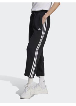 adidas Spodnie dresowe Essentials 3-Stripes Open Hem Fleece HZ5748 Czarny Loose Fit ze sklepu MODIVO w kategorii Spodnie damskie - zdjęcie 168577809