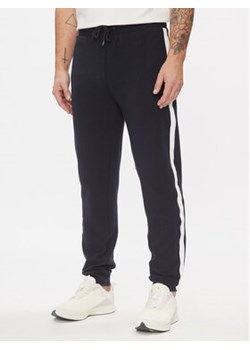 Tommy Hilfiger Spodnie dresowe UM0UM03013 Granatowy Regular Fit ze sklepu MODIVO w kategorii Spodnie męskie - zdjęcie 168593309