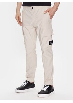 Calvin Klein Jeans Spodnie materiałowe J30J322922 Beżowy Skinny Fit ze sklepu MODIVO w kategorii Spodnie męskie - zdjęcie 168594508