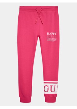 Guess Spodnie dresowe J3YQ11 KA6R4 Różowy Relaxed Fit ze sklepu MODIVO w kategorii Spodnie dziewczęce - zdjęcie 168612477