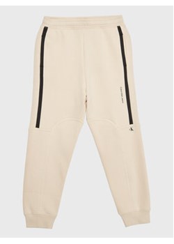 Calvin Klein Jeans Spodnie dresowe Seaming Skater IB0IB01506 Beżowy Regular Fit ze sklepu MODIVO w kategorii Spodnie chłopięce - zdjęcie 168622968