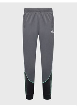 adidas Spodnie dresowe Tricot Sst HI3006 Szary Regular Fit ze sklepu MODIVO w kategorii Spodnie męskie - zdjęcie 168666466