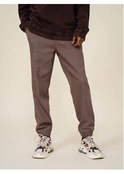 Outhorn Spodnie dresowe OTHSS23TTROM190 Brązowy Regular Fit ze sklepu MODIVO w kategorii Spodnie męskie - zdjęcie 168717078