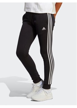 adidas Spodnie dresowe Essentials 3-Stripes French Terry Cuffed Joggers IC8770 Czarny Slim Fit ze sklepu MODIVO w kategorii Spodnie damskie - zdjęcie 169182047