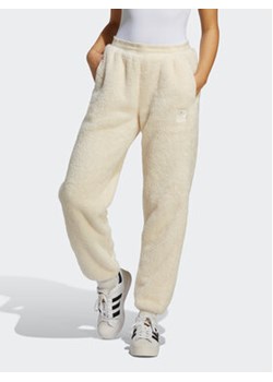 adidas Spodnie dresowe Essentials+ Fluffy Teddy IC2256 Écru Loose Fit ze sklepu MODIVO w kategorii Spodnie damskie - zdjęcie 169231286