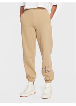 Calvin Klein Jeans Spodnie dresowe J20J220265 Beżowy Relaxed Fit ze sklepu MODIVO w kategorii Spodnie damskie - zdjęcie 169439069
