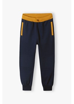 Granatowe spodnie dresowe dla chłopca ze sklepu 5.10.15 w kategorii Spodnie chłopięce - zdjęcie 169693007