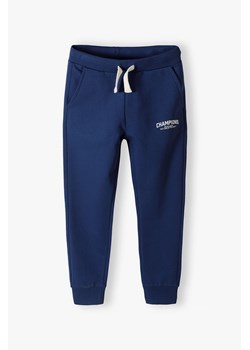 Granatowe spodnie dresowe slim fit z bawełny- Champion ze sklepu 5.10.15 w kategorii Spodnie chłopięce - zdjęcie 169711398