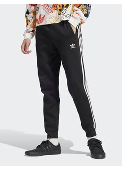 adidas Spodnie dresowe adicolor 3-Stripes IU2353 Czarny Slim Fit ze sklepu MODIVO w kategorii Spodnie męskie - zdjęcie 169747808
