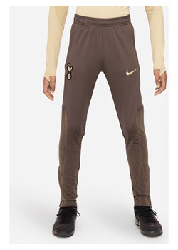Dzianinowe spodnie piłkarskie dla dużych dzieci Nike Dri-FIT Tottenham Hotspur Strike (wersja trzecia) - Brązowy ze sklepu Nike poland w kategorii Spodnie chłopięce - zdjęcie 169758365