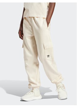 adidas Spodnie dresowe Essentials IR5906 Beżowy Loose Fit ze sklepu MODIVO w kategorii Spodnie damskie - zdjęcie 169896539