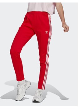 adidas Spodnie dresowe Adicolor SST Tracksuit Bottoms IB5917 Czerwony Slim Fit ze sklepu MODIVO w kategorii Spodnie damskie - zdjęcie 170149049