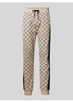 Spodnie dresowe o kroju regular fit z nadrukiem z logo na całej powierzchni ze sklepu Peek&Cloppenburg  w kategorii Spodnie męskie - zdjęcie 170407538