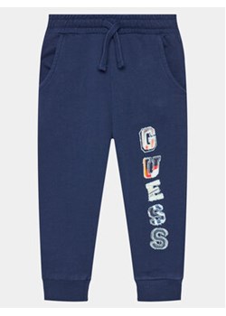 Guess Spodnie dresowe N4GQ11 KA6R3 Granatowy Regular Fit ze sklepu MODIVO w kategorii Spodnie chłopięce - zdjęcie 170477037