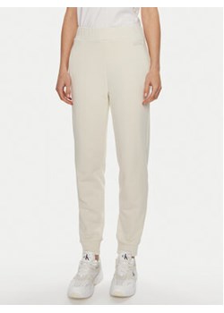 Calvin Klein Spodnie dresowe Micro Logo K20K206632 Écru Regular Fit ze sklepu MODIVO w kategorii Spodnie damskie - zdjęcie 170712917