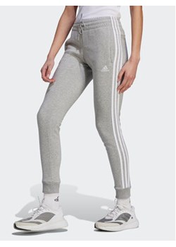 adidas Spodnie dresowe Essentials 3-Stripes IL3282 Szary Slim Fit ze sklepu MODIVO w kategorii Spodnie damskie - zdjęcie 170744976