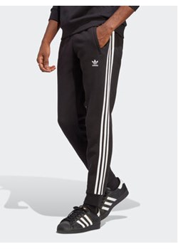 adidas Spodnie dresowe adicolor Classics 3-Stripes IA4794 Czarny Fitted Fit ze sklepu MODIVO w kategorii Spodnie męskie - zdjęcie 170771609