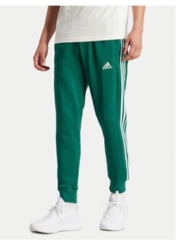 adidas Spodnie dresowe Essentials IS1392 Zielony Regular Fit ze sklepu MODIVO w kategorii Spodnie męskie - zdjęcie 171419987