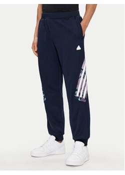 adidas Spodnie dresowe Future Icons Allover Print IJ8853 Granatowy Regular Fit ze sklepu MODIVO w kategorii Spodnie męskie - zdjęcie 171992429