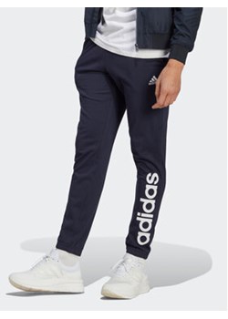 adidas Spodnie dresowe Essentials IC0056 Granatowy Regular Fit ze sklepu MODIVO w kategorii Spodnie męskie - zdjęcie 172178136