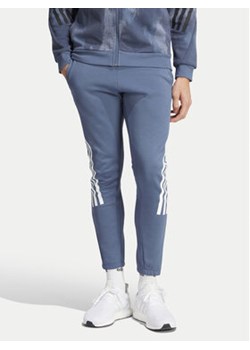 adidas Spodnie dresowe Future Icons 3-Stripes IR9194 Niebieski Slim Fit ze sklepu MODIVO w kategorii Spodnie męskie - zdjęcie 172187767