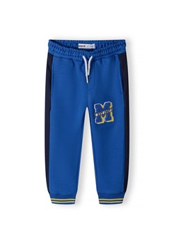 Dresowe niebieskie spodnie z aplikacją "M" dla chłopca ze sklepu 5.10.15 w kategorii Spodnie chłopięce - zdjęcie 173013276