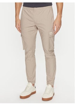 Calvin Klein Jeans Joggery Skinny Cargo J30J327614 Beżowy Skinny Fit ze sklepu MODIVO w kategorii Spodnie męskie - zdjęcie 176971576