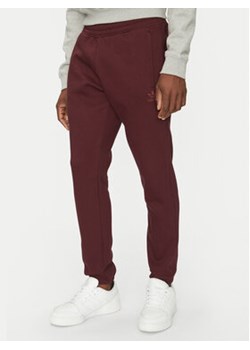 adidas Spodnie dresowe Trefoil Essentials JD2420 Bordowy Slim Fit ze sklepu MODIVO w kategorii Spodnie męskie - zdjęcie 178172057