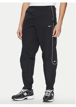 Nike Spodnie dresowe FB8620 Czarny Regular Fit ze sklepu MODIVO w kategorii Spodnie męskie - zdjęcie 178769409