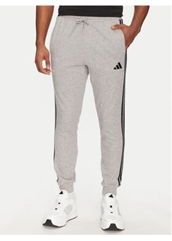 adidas Spodnie dresowe Essential 3-Stripes JE6346 Szary Regular Fit ze sklepu MODIVO w kategorii Spodnie męskie - zdjęcie 178846529