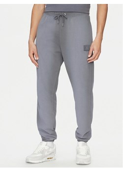 Nike Spodnie dresowe FV7253 Szary Standard Fit ze sklepu MODIVO w kategorii Spodnie męskie - zdjęcie 181040406