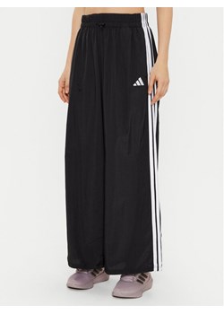 adidas Spodnie dresowe Essentials 3-Stripes JE1306 Czarny Loose Fit ze sklepu MODIVO w kategorii Spodnie damskie - zdjęcie 181051679