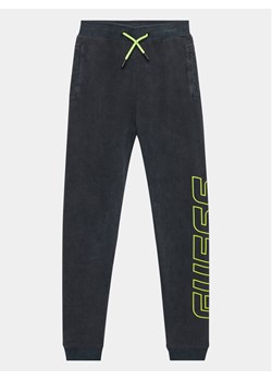 Guess Spodnie dresowe L3BQ14 KBYX0 Czarny Relaxed Fit ze sklepu MODIVO w kategorii Spodnie chłopięce - zdjęcie 181052058