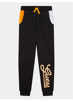 Guess Spodnie dresowe L3YQ34 KA6R3 Czarny Relaxed Fit ze sklepu MODIVO w kategorii Spodnie chłopięce - zdjęcie 181052255