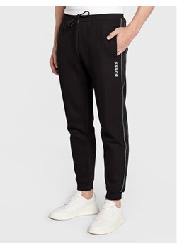 Guess Spodnie dresowe Mickey Z2YB09 KB3P2 Czarny Regular Fit ze sklepu MODIVO w kategorii Spodnie męskie - zdjęcie 181073859