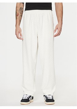 adidas Spodnie dresowe Monogram Track JP4429 Biały Regular Fit ze sklepu MODIVO w kategorii Spodnie męskie - zdjęcie 181080325