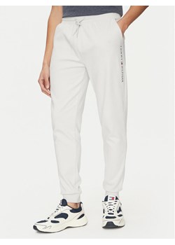Tommy Hilfiger Spodnie dresowe UM0UM03348 Beżowy Regular Fit ze sklepu MODIVO w kategorii Spodnie męskie - zdjęcie 181091695