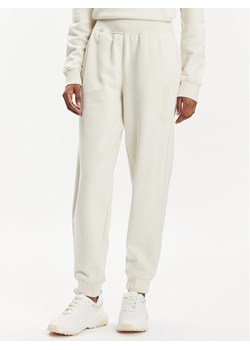 Asics Spodnie dresowe Logo 2032C844 Beżowy Regular Fit ze sklepu MODIVO w kategorii Spodnie damskie - zdjęcie 181106279