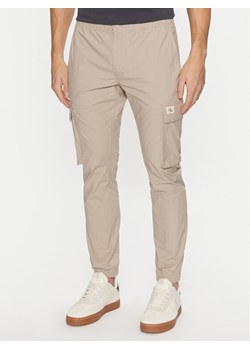 Calvin Klein Jeans Joggery J30J327614 Beżowy Skinny Fit ze sklepu MODIVO w kategorii Spodnie męskie - zdjęcie 181115487