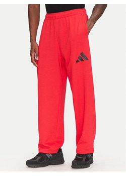 adidas Spodnie dresowe Essentials JF3601 Czerwony Loose Fit ze sklepu MODIVO w kategorii Spodnie męskie - zdjęcie 181118979