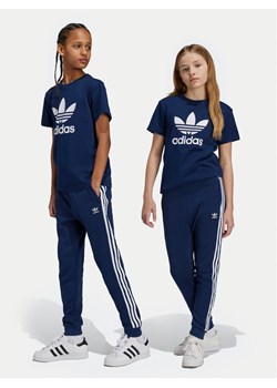adidas Spodnie dresowe Trefoil IY7486 Granatowy Regular Fit ze sklepu MODIVO w kategorii Spodnie chłopięce - zdjęcie 181126036