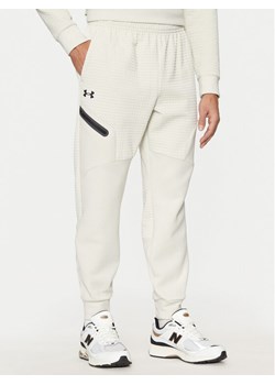Under Armour Spodnie dresowe UA Unstoppable 1386544 Écru Regular Fit ze sklepu MODIVO w kategorii Spodnie męskie - zdjęcie 181127999