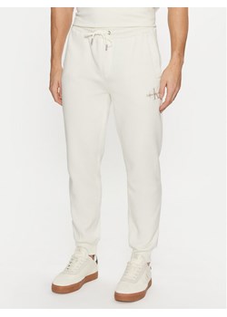 Calvin Klein Jeans Spodnie dresowe Monologo Hwk Pant J30J325658 Écru Regular Fit ze sklepu MODIVO w kategorii Spodnie męskie - zdjęcie 181128839