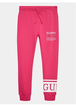 Guess Spodnie dresowe J3YQ11 KA6R4 Różowy Relaxed Fit ze sklepu MODIVO w kategorii Spodnie dziewczęce - zdjęcie 181129866