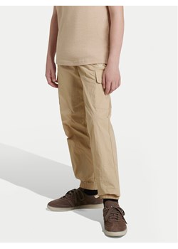 adidas Spodnie dresowe IX7620 Beżowy Regular Fit ze sklepu MODIVO w kategorii Spodnie chłopięce - zdjęcie 181130018