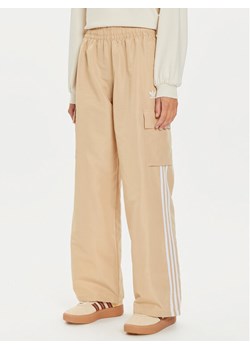 adidas Spodnie dresowe adicolor 3-Stripes IZ0717 Beżowy Loose Fit ze sklepu MODIVO w kategorii Spodnie damskie - zdjęcie 181132535