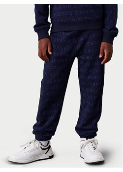 Calvin Klein Jeans Spodnie dresowe Ckj Aop Jogger IB0IB02323 Granatowy Regular Fit ze sklepu MODIVO w kategorii Spodnie chłopięce - zdjęcie 181132796