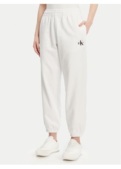 Calvin Klein Jeans Spodnie dresowe Monologo LV047B235G Biały Regular Fit ze sklepu MODIVO w kategorii Spodnie damskie - zdjęcie 181155325