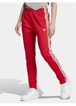 adidas Spodnie dresowe adicolor SST IK6603 Czerwony Slim Fit ze sklepu MODIVO w kategorii Spodnie damskie - zdjęcie 181157516